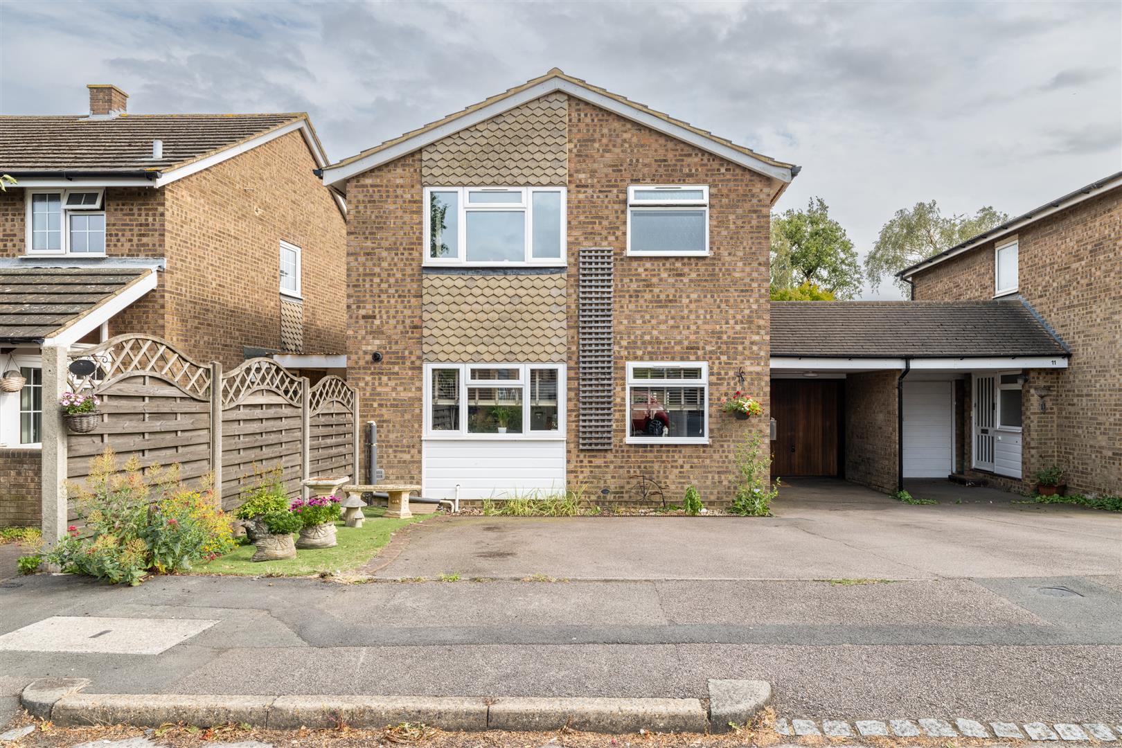 Detached brick house with driveway and garden